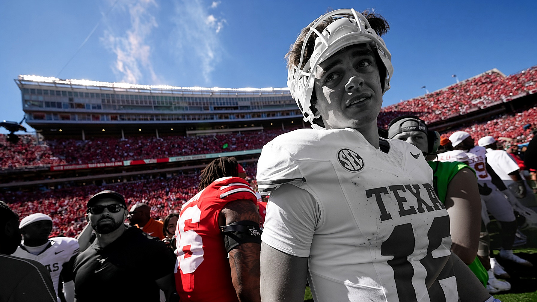 Arch Manning in a Texas jersey after the game: the figures in black and white; stadium crowd and sky in color. Wire photograph.