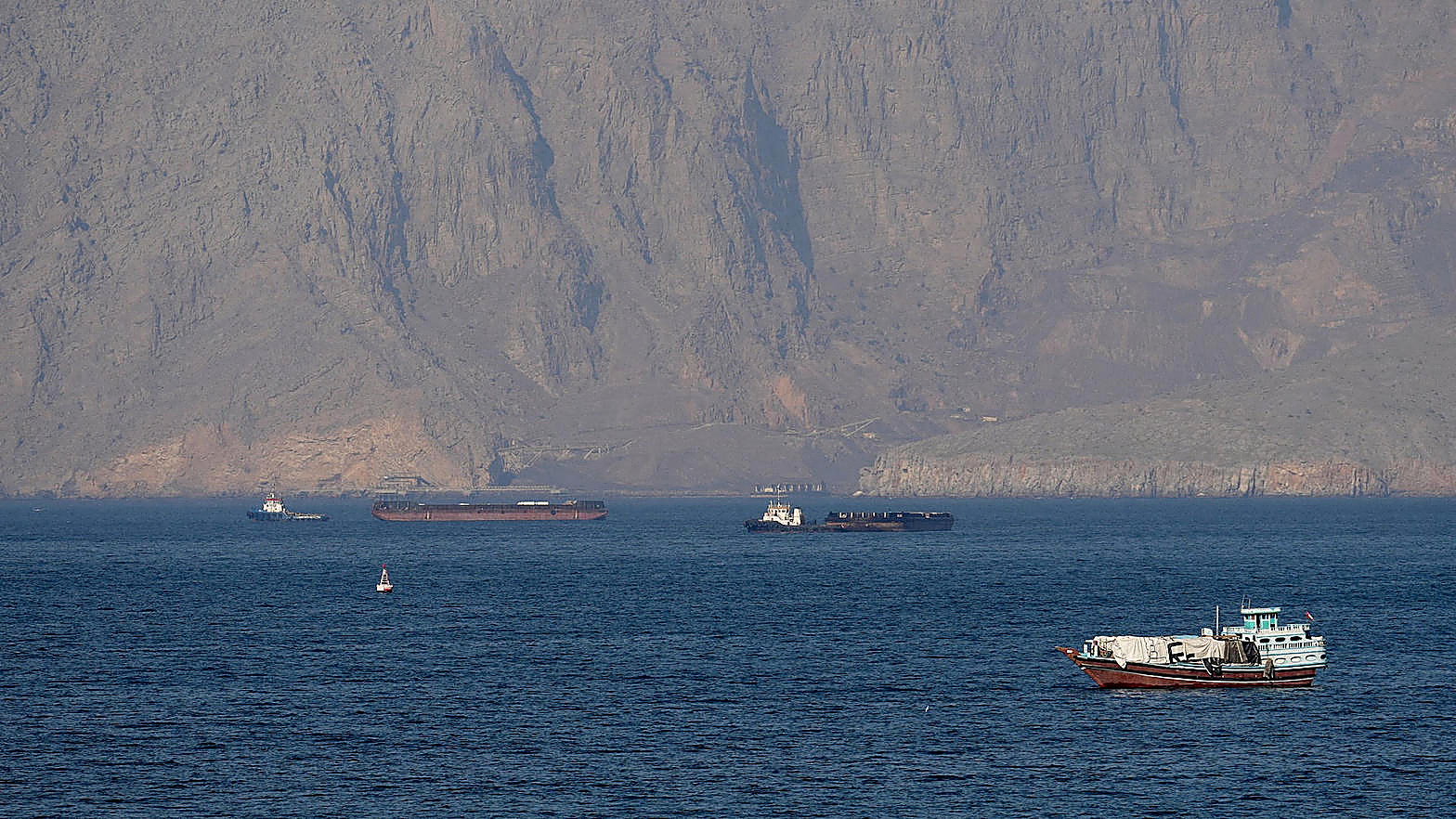 Tankers on the water in the Strait of Hormuz, June 22, with mountains behind them. This is not a Saudi refinery.