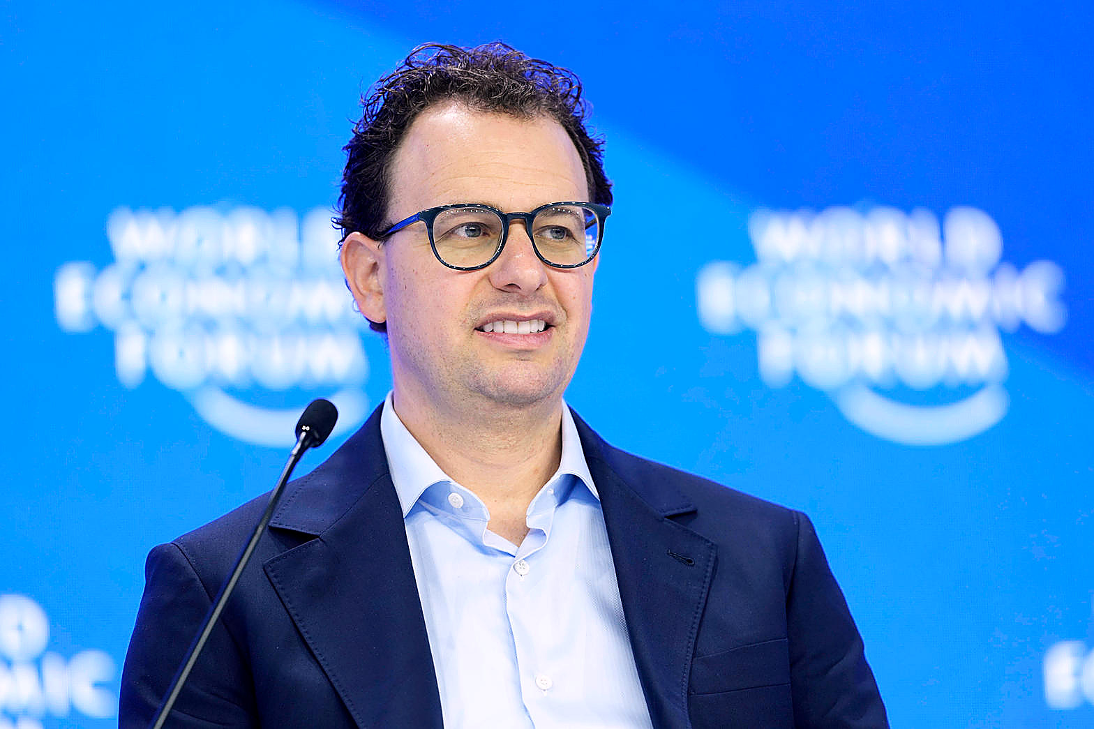 Dario Amodei, Anthropic chief executive, at a microphone, World Economic Forum backdrop, in color. Person plate.