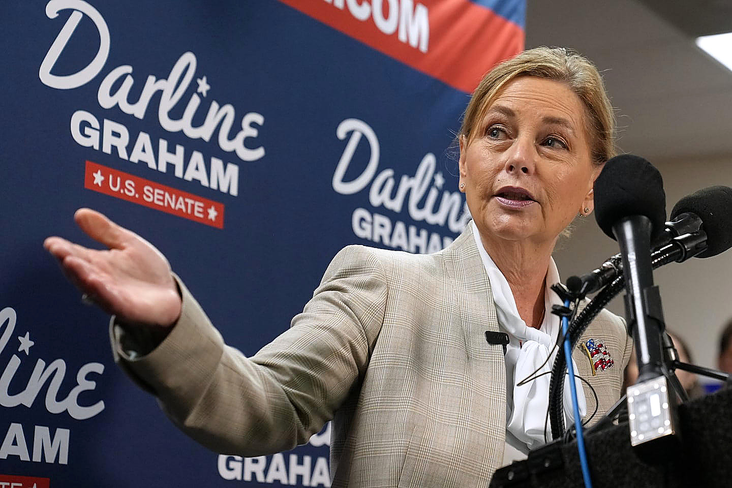 Senator Darline Graham speaks at a microphone, her right hand open. Dr. Annie Andrews is not in the frame. This is not Wednesday's poll.