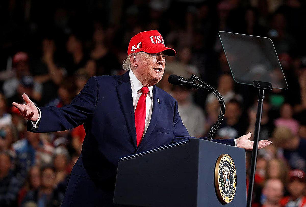 President Trump, both arms out at a rally microphone, as a new poll finds voters fault him on the cost of living.