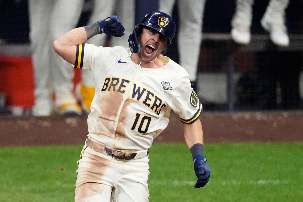 Sal Frelick, number 10, shouts with a fist raised, dirt on his white Brewers uniform, in Game 2.