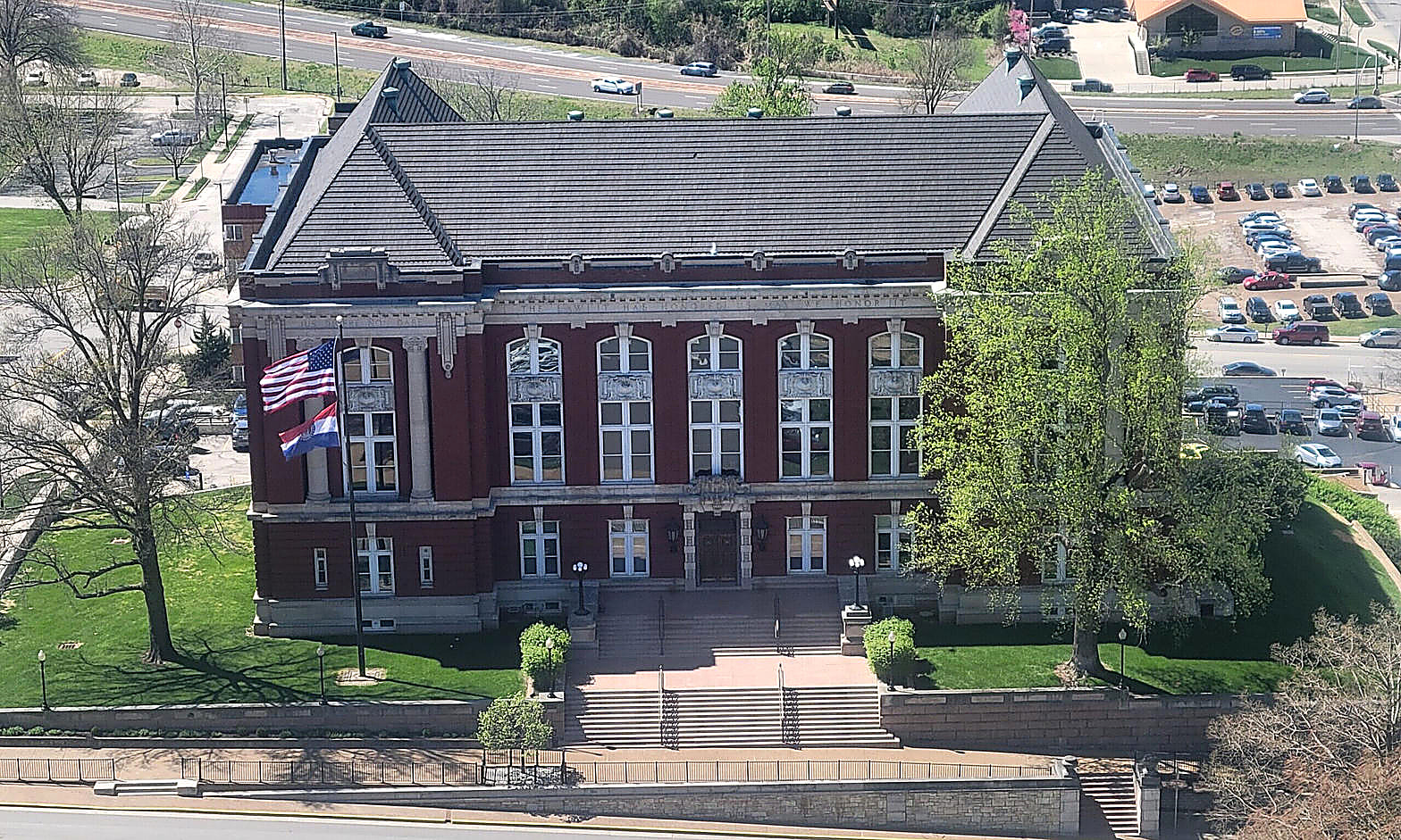 The Supreme Court of Missouri Building, Jefferson City: red brick, gray slate roof, U.S. and Missouri flags on the lawn. News photograph of the building, no portraits.