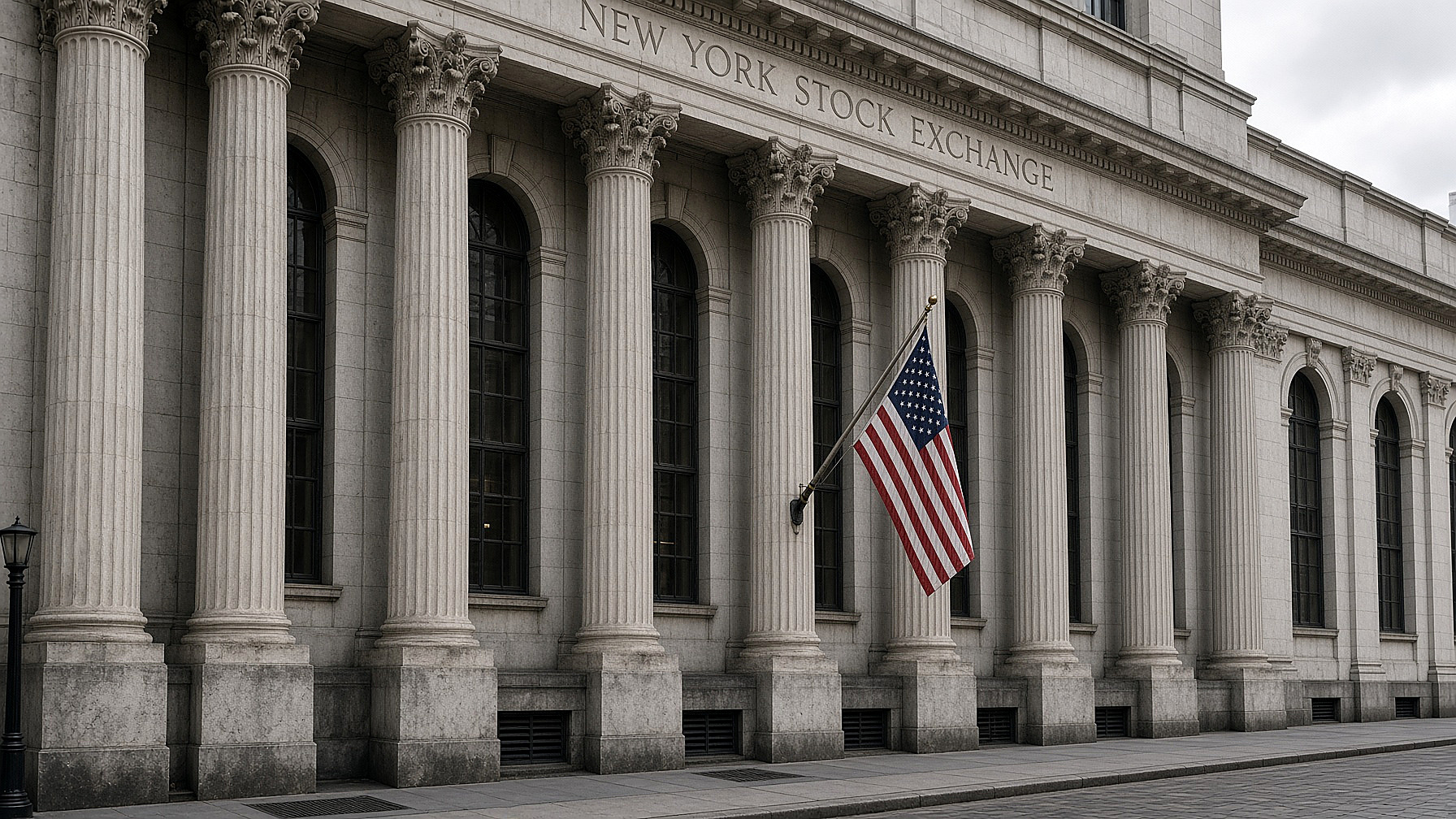 The New York Stock Exchange facade, marble columns and the carved name, an American flag on the pole, stone and sky in color. No figures in the frame.