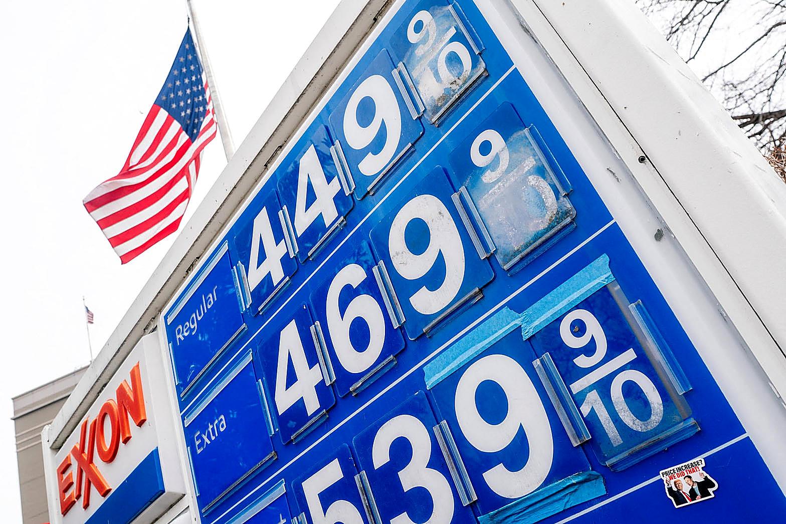 A gasoline price sign stands under an American flag as September inflation rose to 3.7 percent.