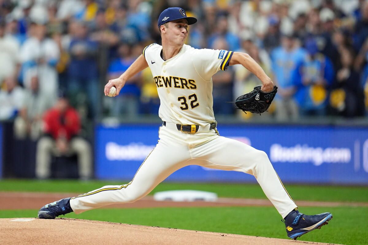 Jacob Misiorowski, number 32, delivers a pitch in a white Brewers uniform, right arm forward.