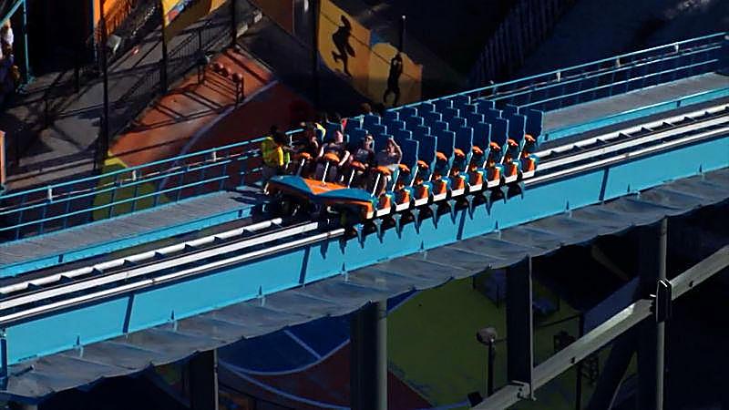 Riders sit in a coaster train at Six Flags Over Georgia after a man was thrown from his seat.
