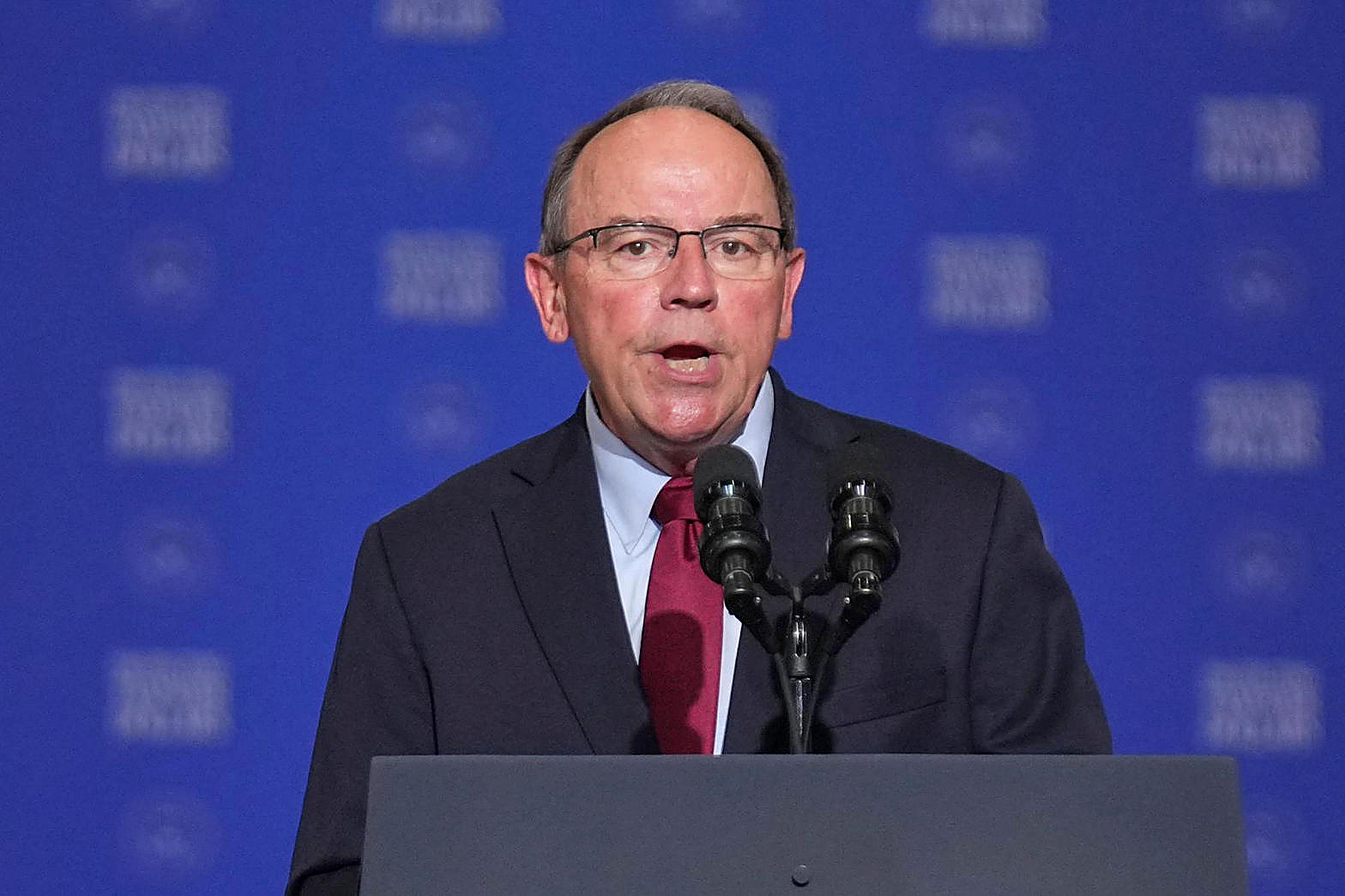 Rep. Tom Tiffany at a podium, full color, blue backdrop. Wire photograph.