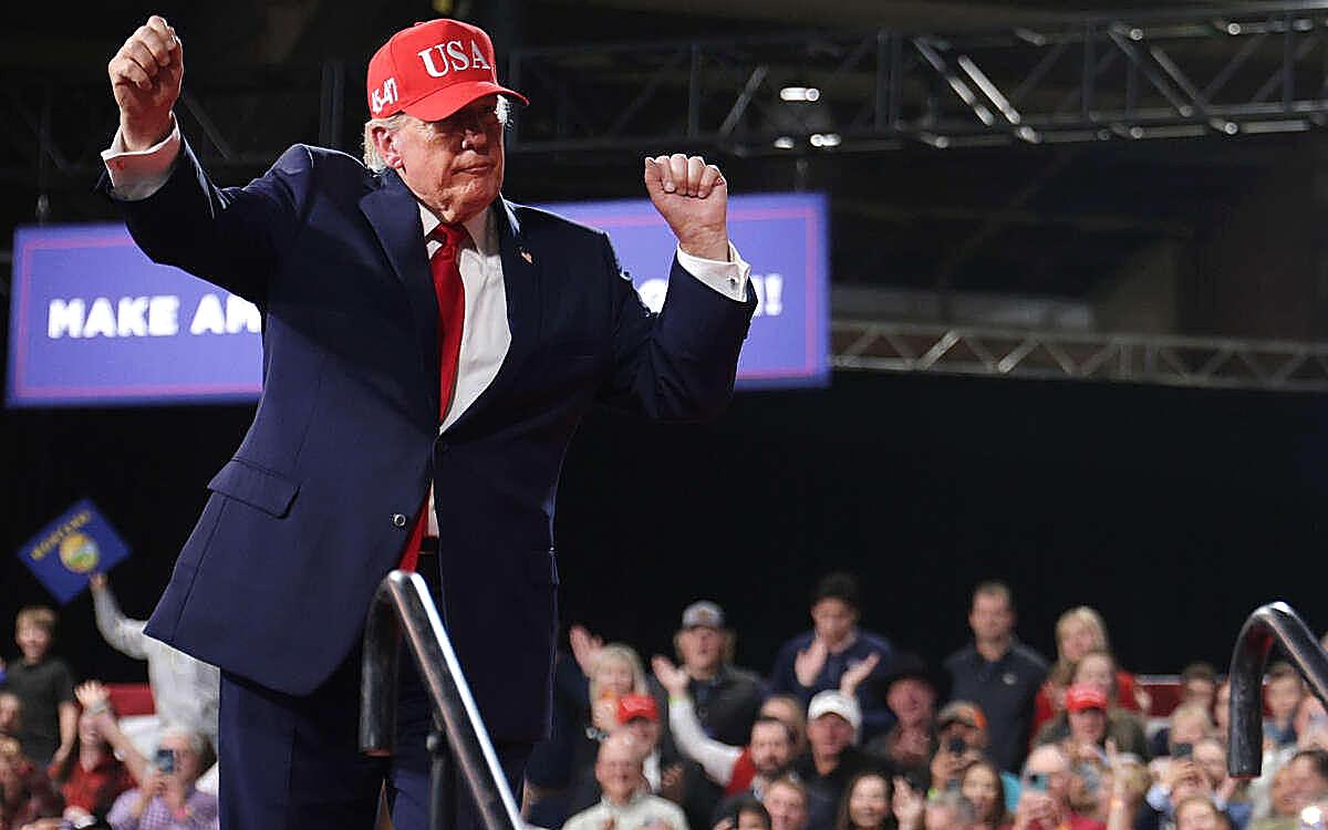 President Trump, both fists raised, on a Kalispell stage as Democrats spend to put him on the air.