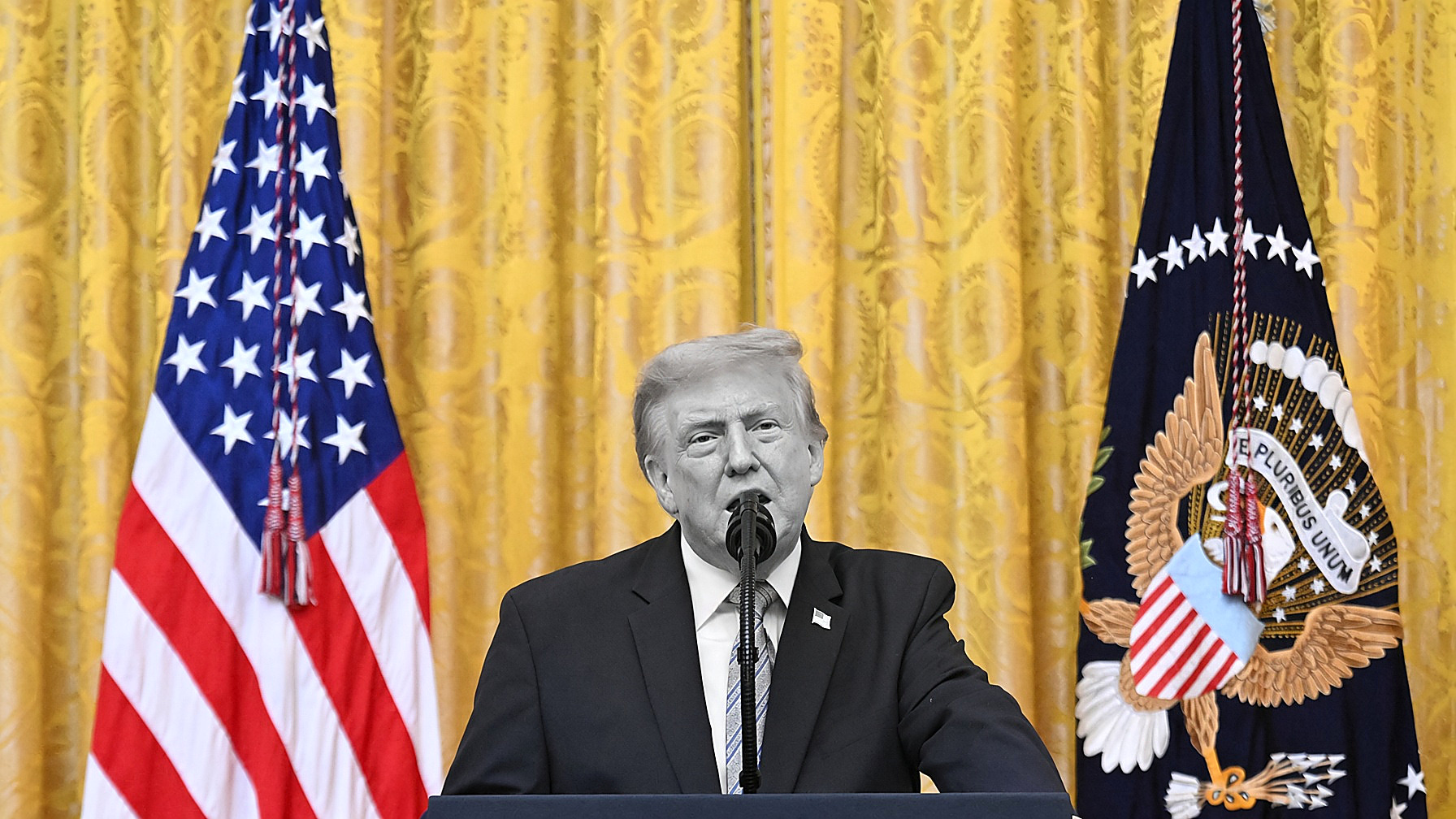 President Trump at a White House podium: the figure in black and white; gold curtains and flags in color. Wire photograph. Portada plate, Tuesday, Sept. 15, 2026.