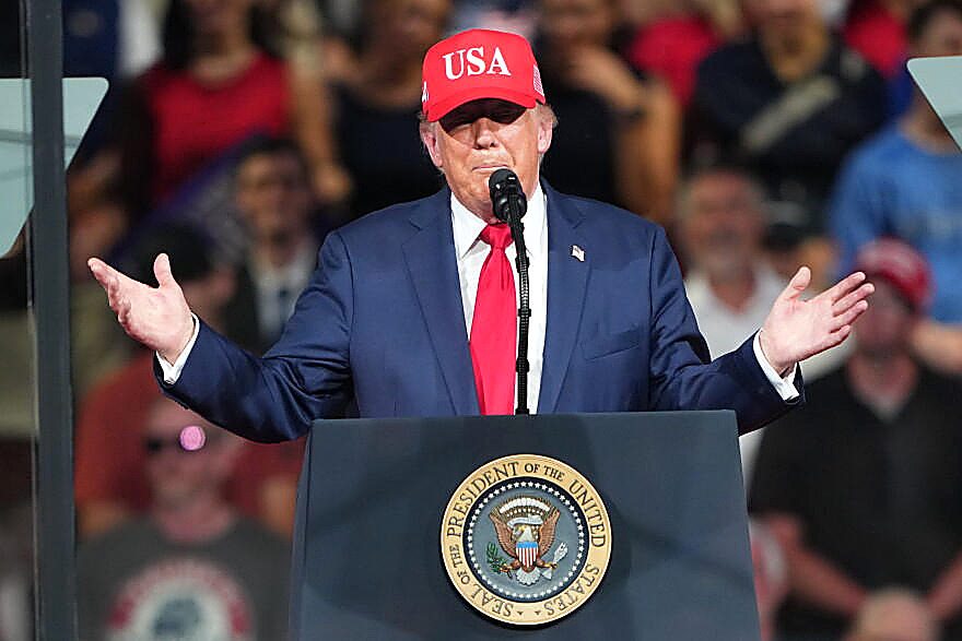 President Trump at a North Carolina podium, full color, red cap and red tie. Wire photograph.