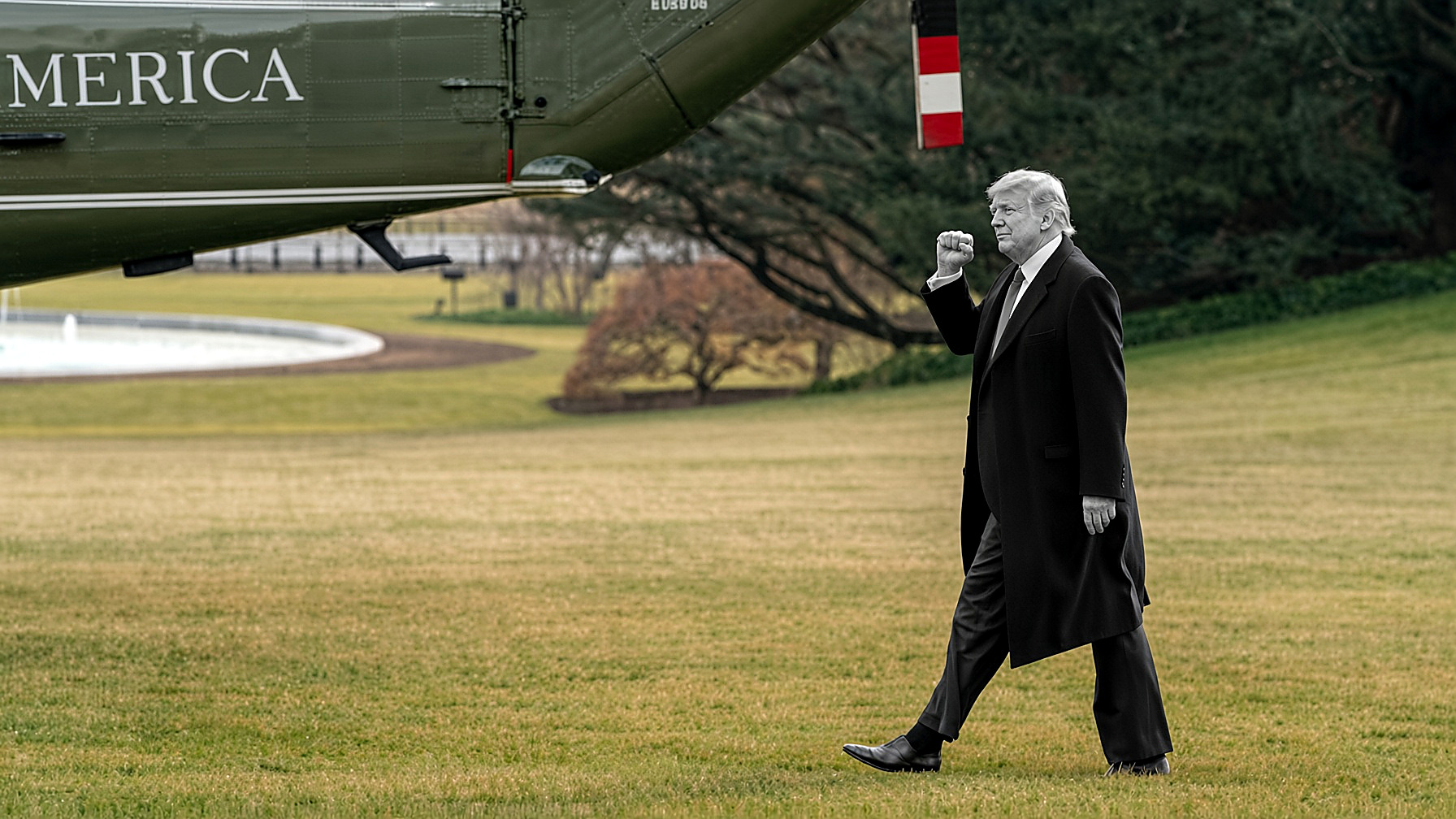 President Trump walking the South Lawn toward Marine One: the figure in black and white — coat, tie, fist — grass, trees and the olive helicopter in color. Editor’s plate for the Dublin note, Saturday, Sept. 12, 2026.