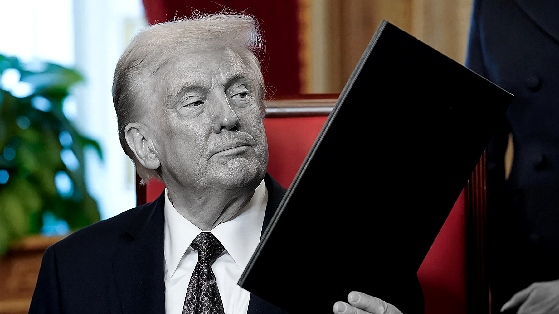 President Trump seated, holding a black folder: the figure in black and white; red leather chair, gold drapes and window in color. Editor’s plate, Dublin, Saturday, Sept. 12, 2026.