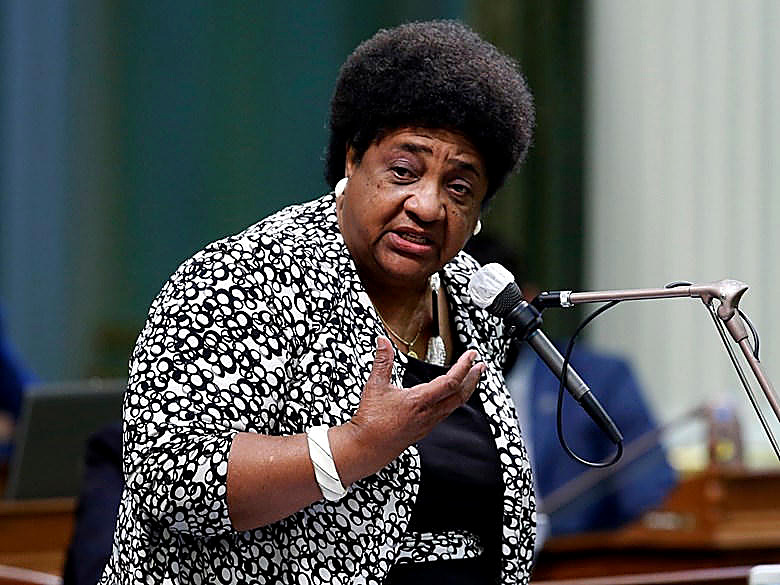 California Secretary of State Shirley Weber at a microphone, full color. Wire photograph.