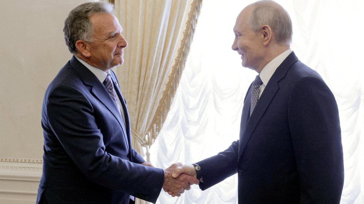 Steve Witkoff and Vladimir Putin shake hands at Constantine Palace, both men in dark suits, curtains behind them.