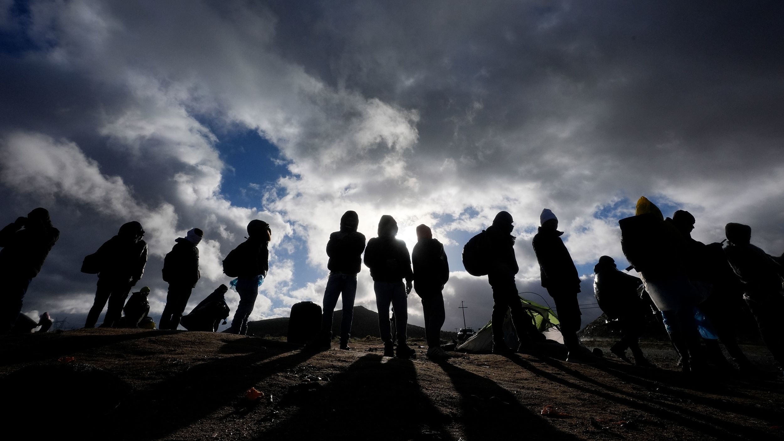 Asylum-seeking migrants wait to be processed in a makeshift campsite after crossing the border with Mexico on February 2, 2024, near Jacumba Hot Springs, California.